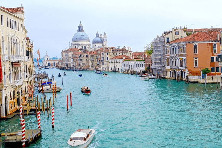 The beautiful aqua blue water of the Grand Canal in Venice Italy. Colouful tall buildings line each side.