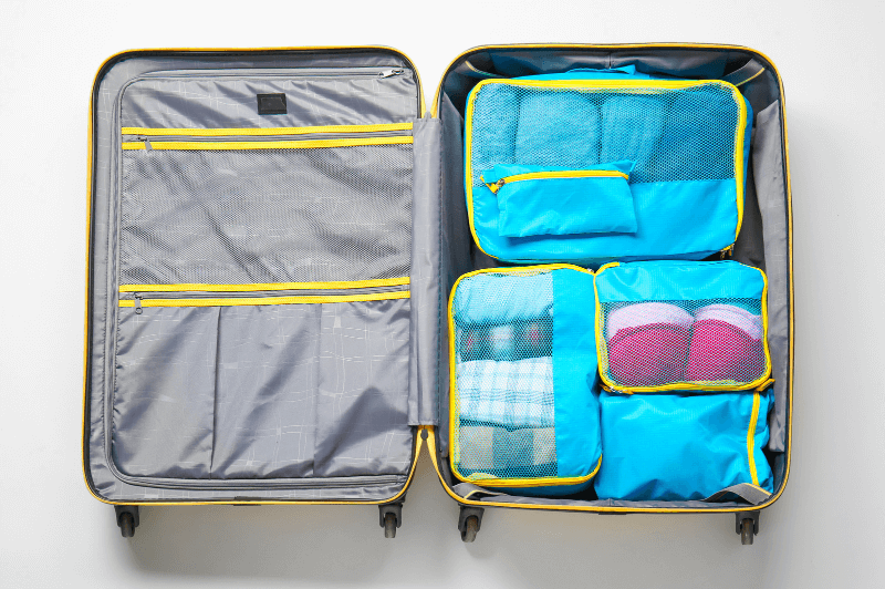 A set of misc packing cubes in a small suitcase.