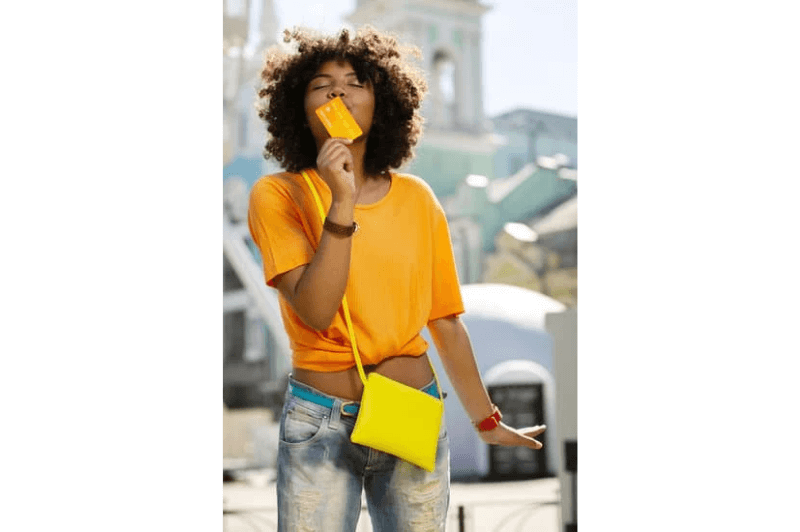 a woman kisses an orange payment card