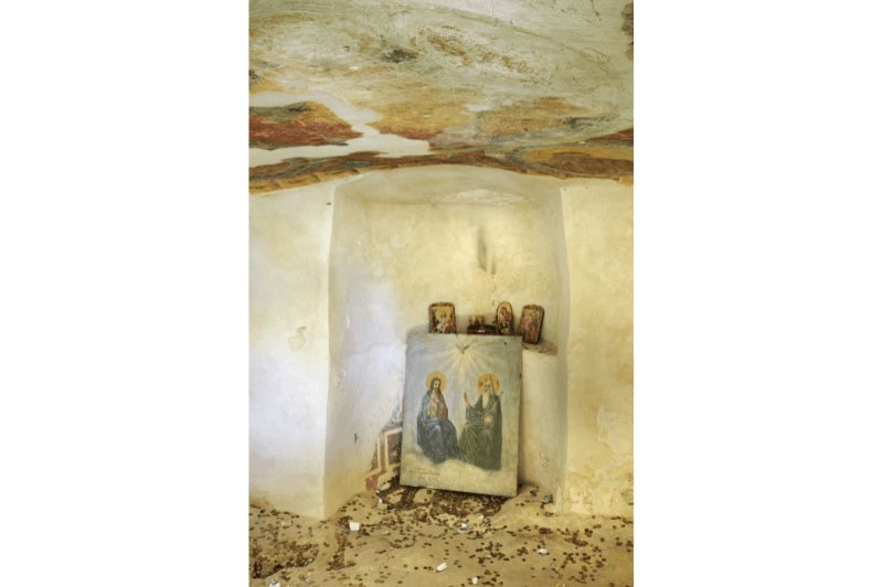 Faded ancient frescoes inside a small white stone room at Aladzha Monastery