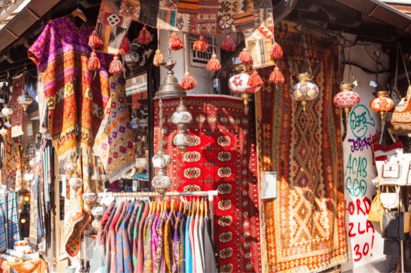 A Turkish market in Sarajevo. Turkish lanterns hang around a wooden market stall containing ornate rugs and clothing