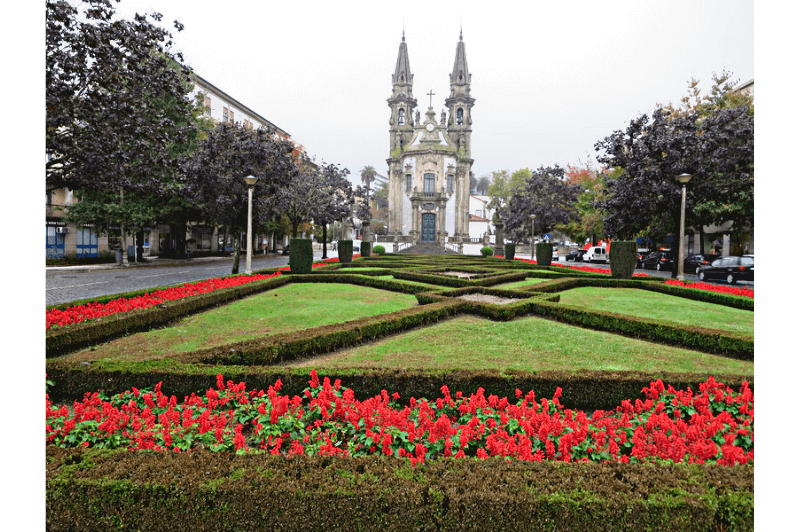 An impressive church sits at the end of a blocks long garden in Guimaraes Portugal