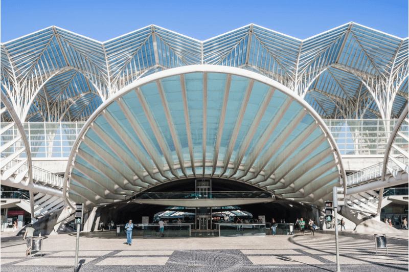 Oriente station in Lisbon. A geometric structure of metal and glass above a round canopy over the entrance of the train station.