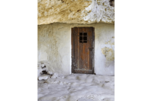 A small wooden door under a rocky overhang at Aladzha Monastery