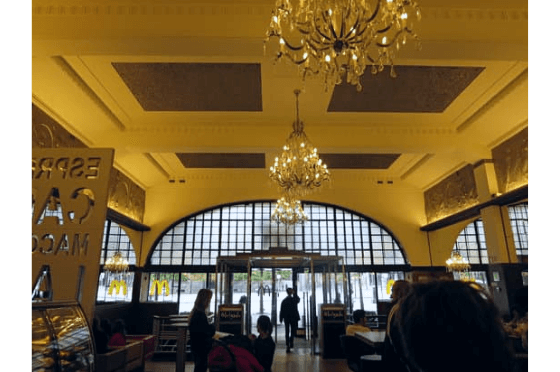 Chandeliers hang inside the art deco building of Imperial McDonalds in Porto Portugal