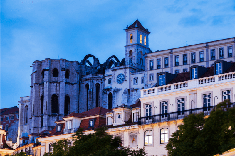 A view of Lisbon's historical buildings and the famous Carmo convent as the sun sets on a winter day