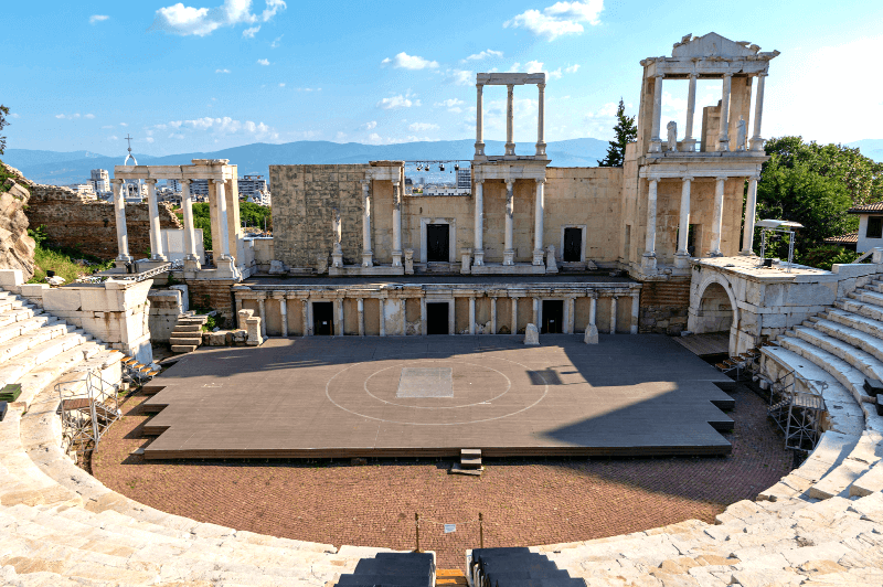 A wide angle shot of the rounded marble seats opening onto the Plovdiv amphitheatre on a sunny day in Bulgaria