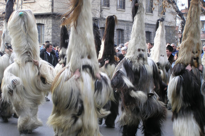 Men dressed up for Kukeri in hairy yeti-like costumes with tall hairy hats in a town in Bulgaria