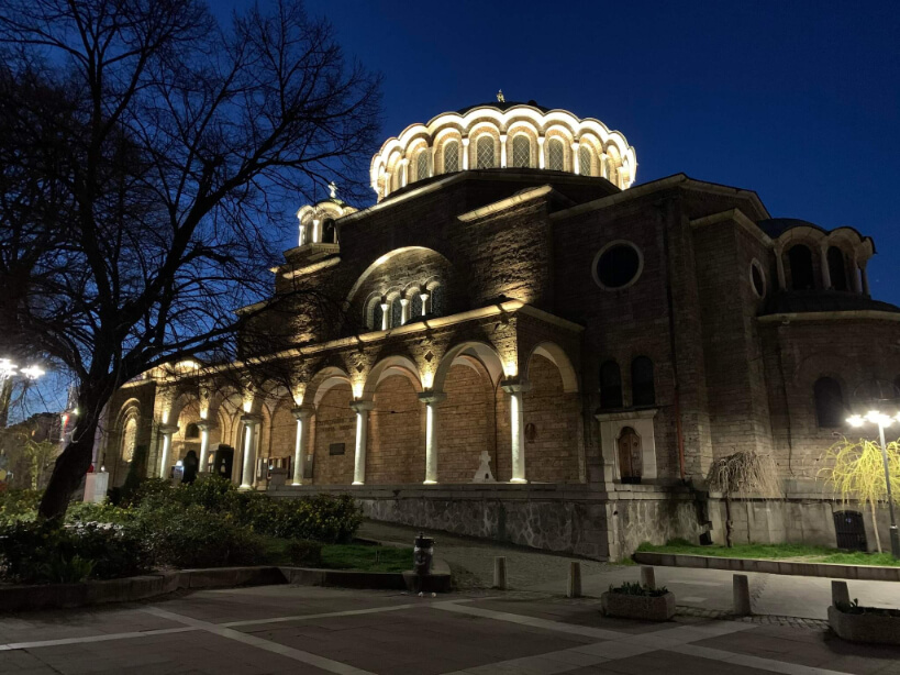 A neo-byzantine style building lit up at night in Sofia