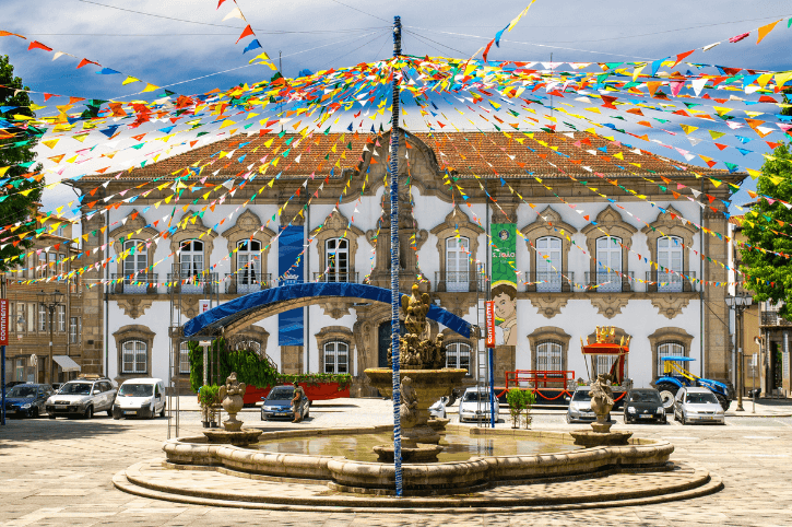 A whitewashed building in Braga portugal with colorful streamers all around