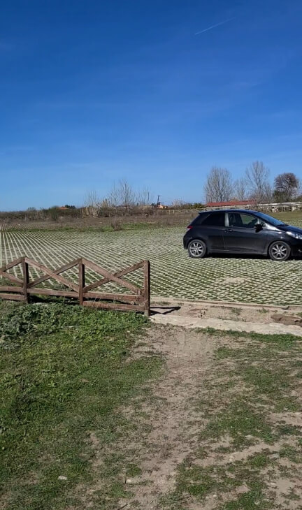 Lower parking lot at Apollonia Archaeological Park with a small black car on a clear blue day