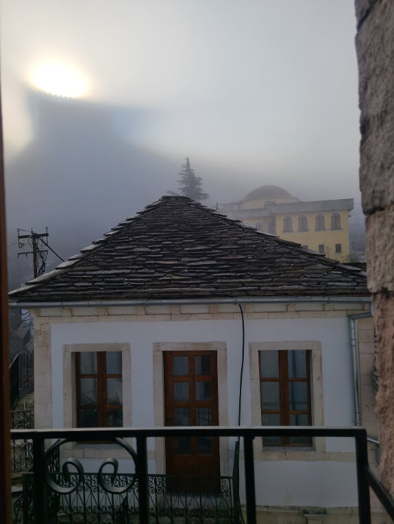 The castle at Gjirokaster silhouetted in the fog with the sun behind it