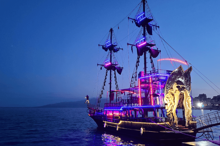 A pirate ship on the calm seas decked out with fluorescent lights